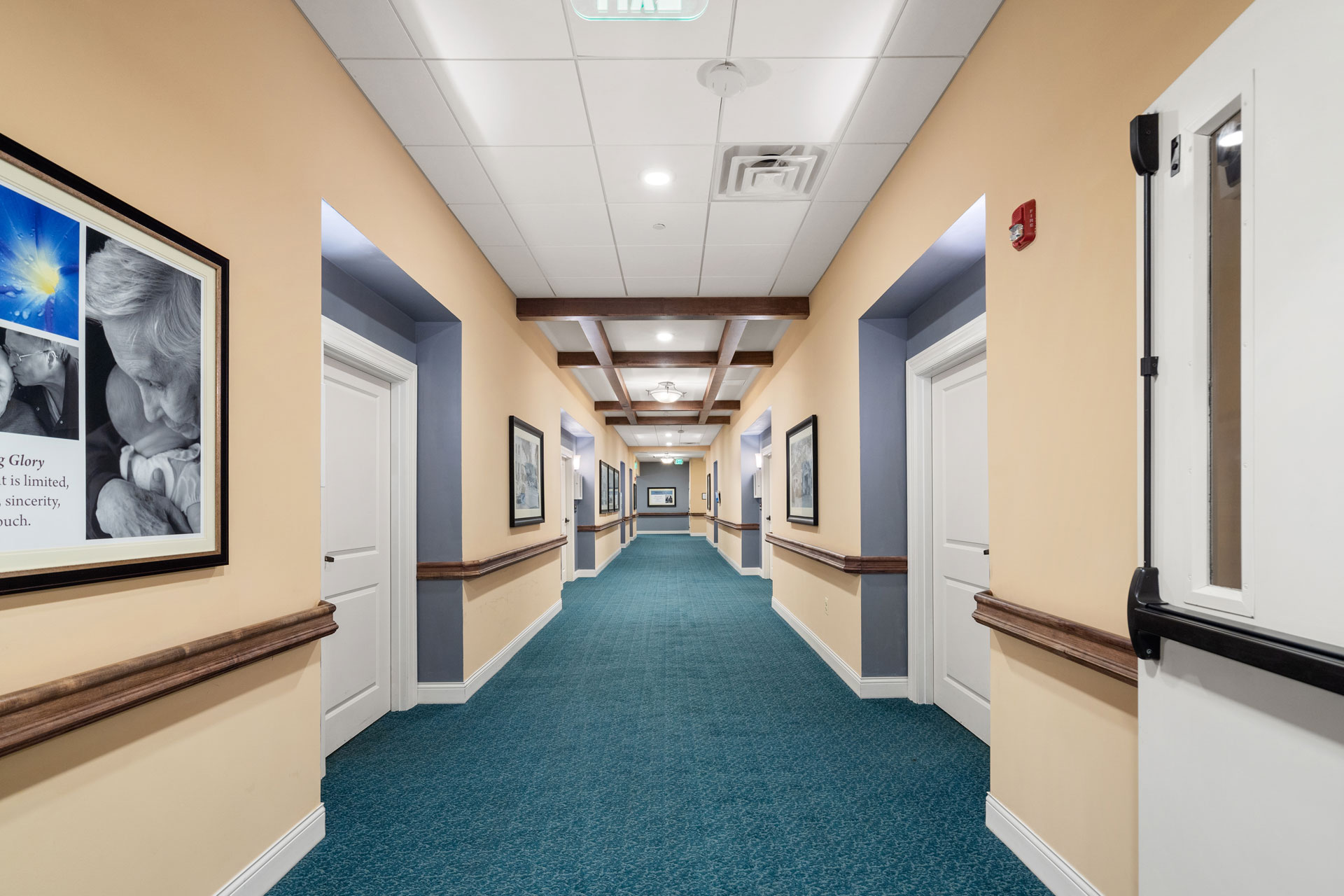 Hallway with tan walls and blue carpet