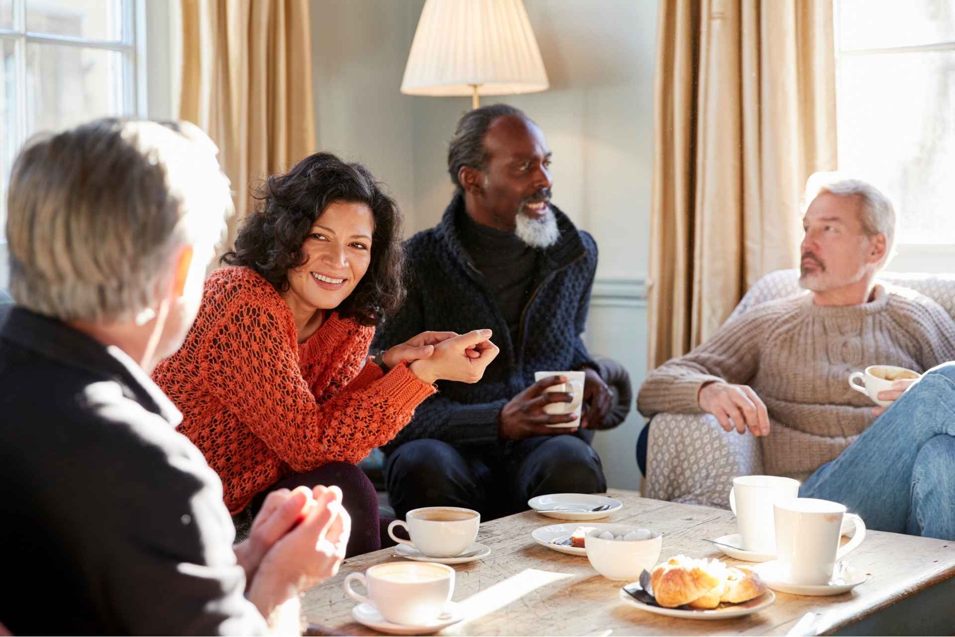 Group Of Middle Aged Friends Meeting Around Coffee table