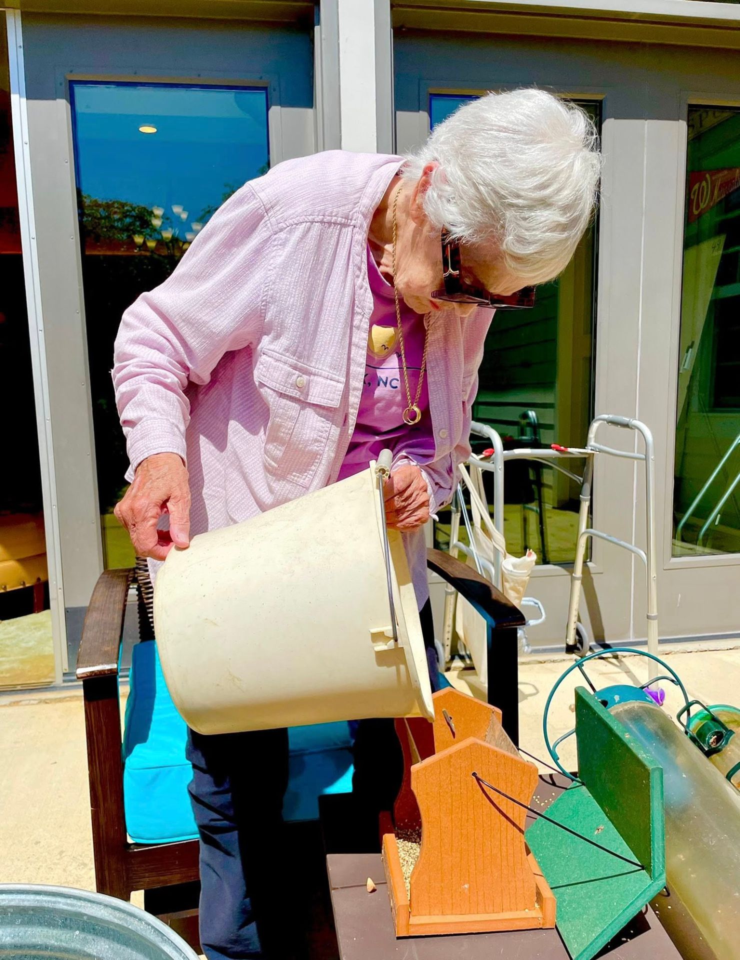 Senior resident filling bird seed